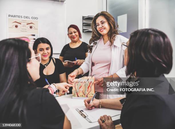 female beautician instructor teaching women at the class - schoonheidsspecialist stockfoto's en -beelden