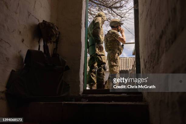 Members of the Ukrainian military stand at the entrance of a bomb shelter amid Russian shelling at a forward position on April 27, 2022 in a...