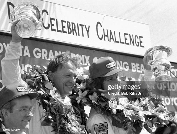 Professional racer Dan Gurney celebrates victory circle with former professional athlete Bruce Jenner at the 1982 Toyota Pro/Celebrity Race at the...