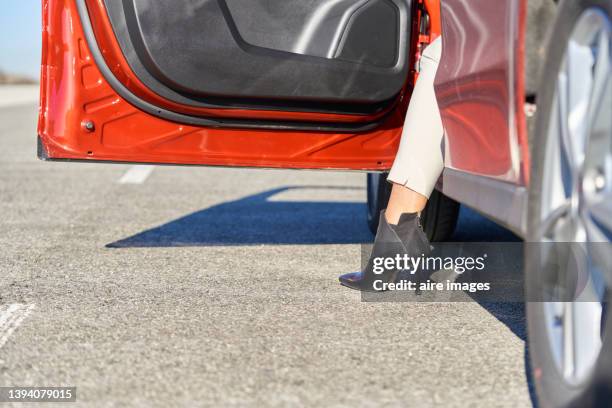 low section of woman stepping out of the car wearing a black high heels boots - sapato botinha - fotografias e filmes do acervo