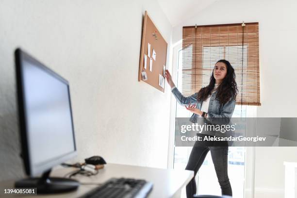 female team leader giving explanation of office tasks for the week pinned on bulleting board - pinning stock pictures, royalty-free photos & images