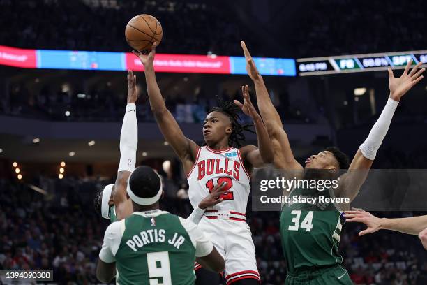 Ayo Dosunmu of the Chicago Bulls is defended by Jrue Holiday and Giannis Antetokounmpo of the Milwaukee Bucks in the first quarter during Game Five...