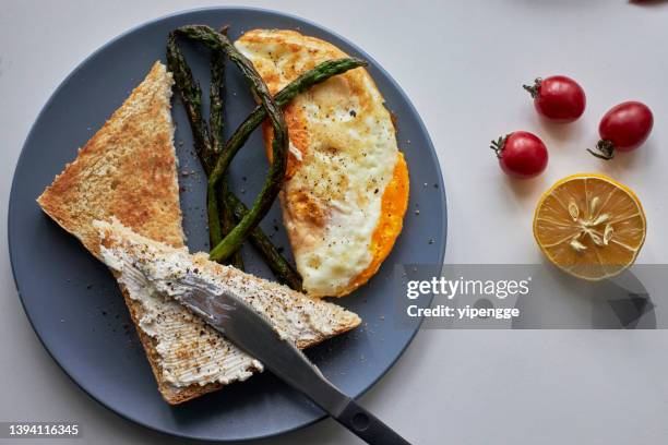 desayuno casero: tostadas, huevo frito y espárragos - untar de mantequilla fotografías e imágenes de stock