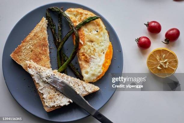 homemade breakfast: toast, fried egg and asparagus - buttering stock pictures, royalty-free photos & images