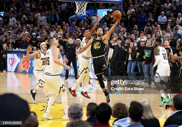 Stephen Curry of the Golden State Warriors makes a basket over Monte Morris of the Denver Nuggets in the final minute of during Game Five of the...