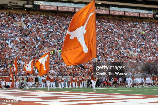 The Texas Longhorns cheerleaders run with flags after a touchdown during the Orange-White Spring Game at Darrell K Royal-Texas Memorial Stadium on...