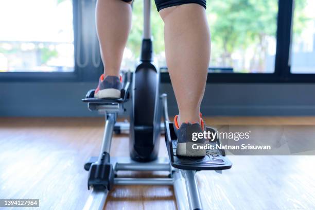 leg of fat woman being run on belt of treadmill machine. - fat loss training stockfoto's en -beelden