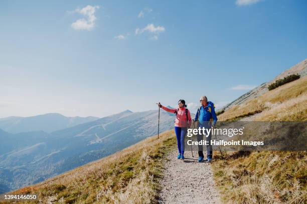 senior couple hiking together. - mountain hiking couple stock pictures, royalty-free photos & images
