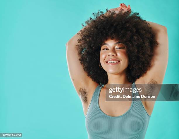 mixed race woman showing armpit hair in the studio - hairy human skin stock pictures, royalty-free photos & images