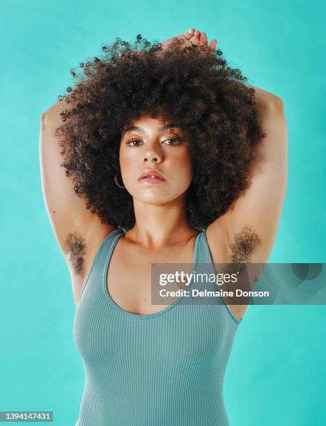 mixed race woman showing armpit hair in the studio - female hairy arms stock pictures, royalty-free photos & images