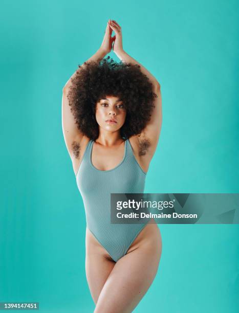 mixed race woman showing armpit hair in the studio - armpit hair woman stock pictures, royalty-free photos & images
