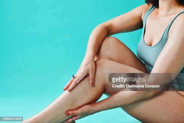 unknown mixed race model touching legs in the studio - bodysuit stock pictures, royalty-free photos & images