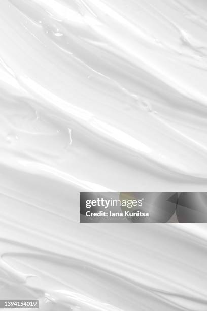 texture of white face cream is smeared. cosmetic products for makeup and skin care. vertical beauty background. - 乳液 ストックフォトと画像
