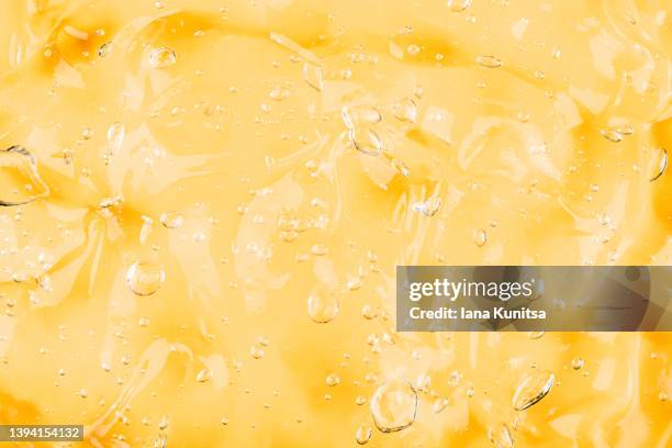 transparent yellow smudged texture. vitamin c. facial serum. antibacterial gel with bubbles. cosmetic products for skincare. - orange creme stock pictures, royalty-free photos & images