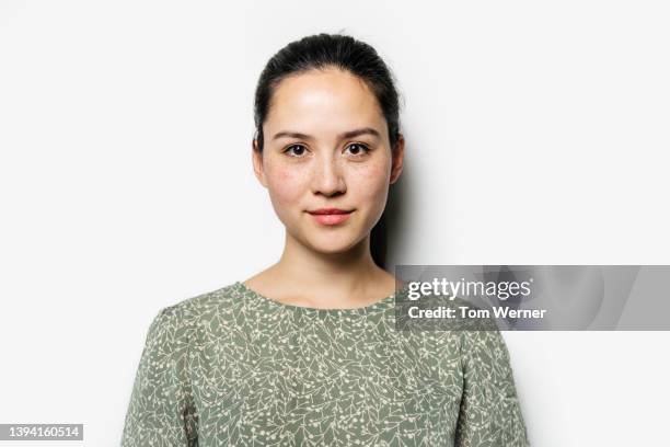 portrait of dark haired woman in green blouse - frontaal stockfoto's en -beelden