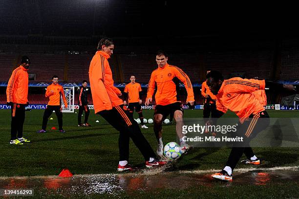 Chelsea players warm up in wet conditions during the Chelsea training session ahead of the UEFA Champions League round of sixteen, first leg match...