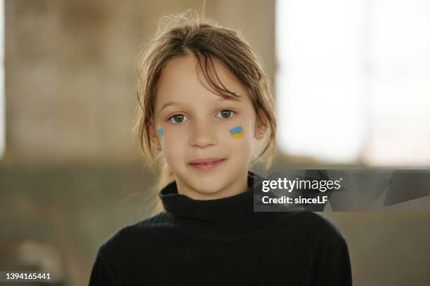 ukrainian girl with a national flag painted on her face - refugee portrait stock pictures, royalty-free photos & images