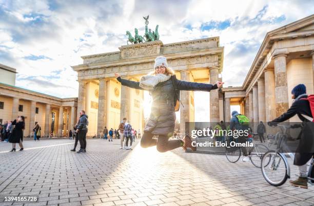 young woman jumping in front of brandeburg gate in berlin - brandenburger tor 個照片及圖片檔