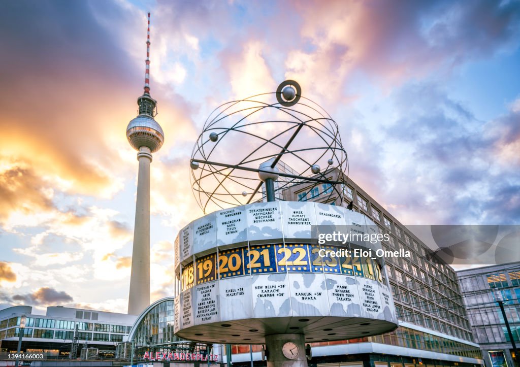 Weltzeituhr und Fernsehturm am Alexanderplatz in Berlin bei Sonnenuntergang, Deutschland