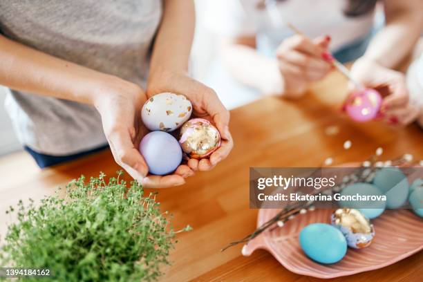 mom and daughter paint eggs for the easter holiday. - easter eggs stock-fotos und bilder