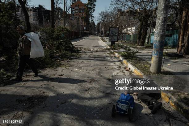Male resident walks past the dead body of a civilian laying on the ground on March 29 in Irpin, Ukraine. The Ukrainian army liberated the city of...