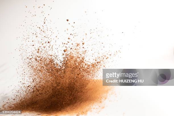 cocoa powder explosion on white background - explosion stockfoto's en -beelden