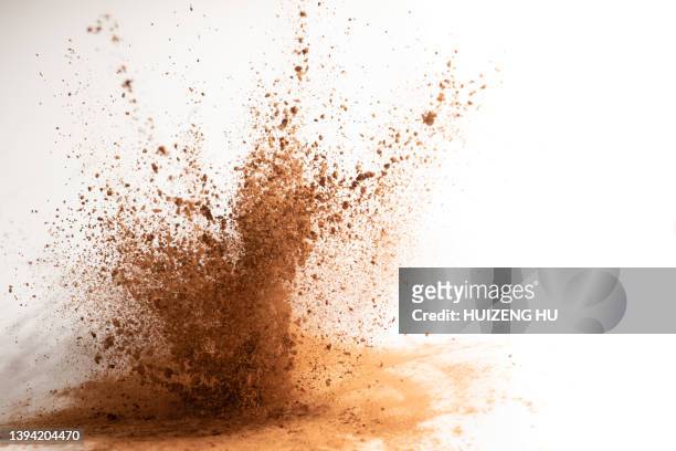 cocoa powder explosion on white background - polvo de cacao fotografías e imágenes de stock