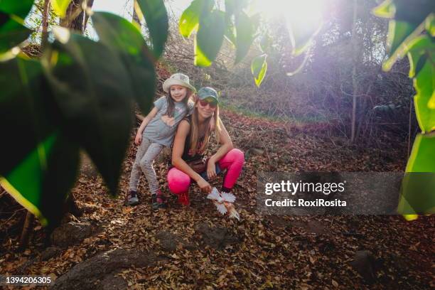 mother and daughter in the forest looking at the camera with hats and casual clothes - cordoba province argentina stock pictures, royalty-free photos & images