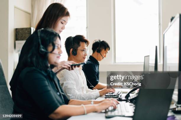 scatto ritagliato di uomini d'affari che lavorano insieme - call centre asian foto e immagini stock
