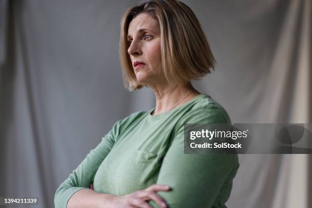 feeling worried - portrait woman 50 serious stockfoto's en -beelden