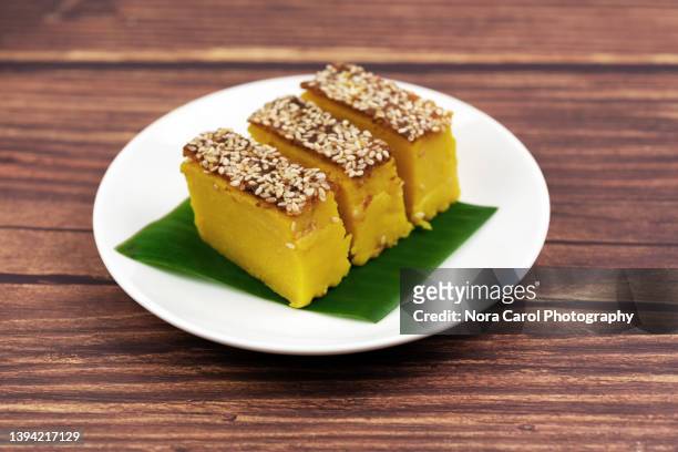 malaysian traditional dessert on a plate - kuih bingka ubi with sesame seed or baked tapioca cassava cake - traditional malay food stock pictures, royalty-free photos & images