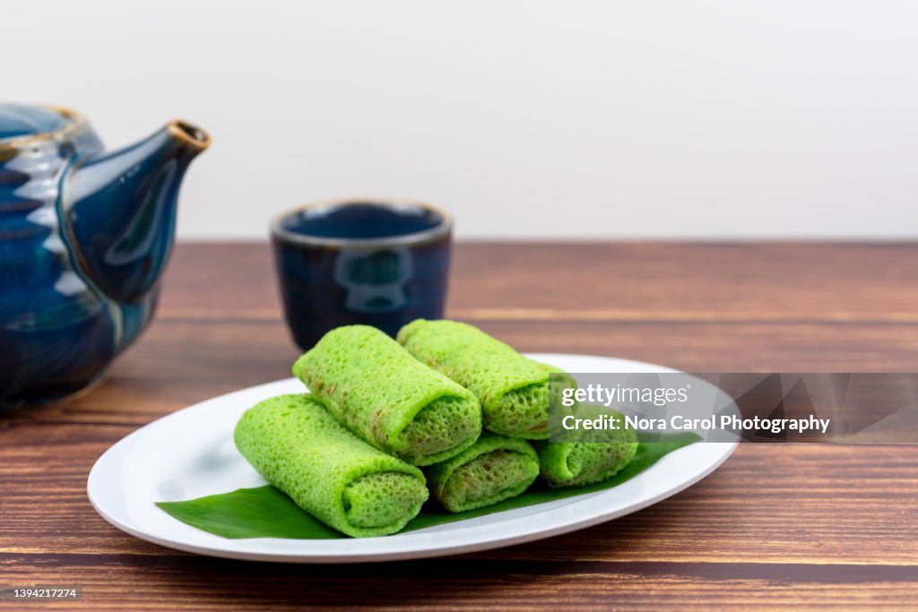 Malaysian Traditional Dessert on a Plate and Hot Tea - Kuih Ketayap