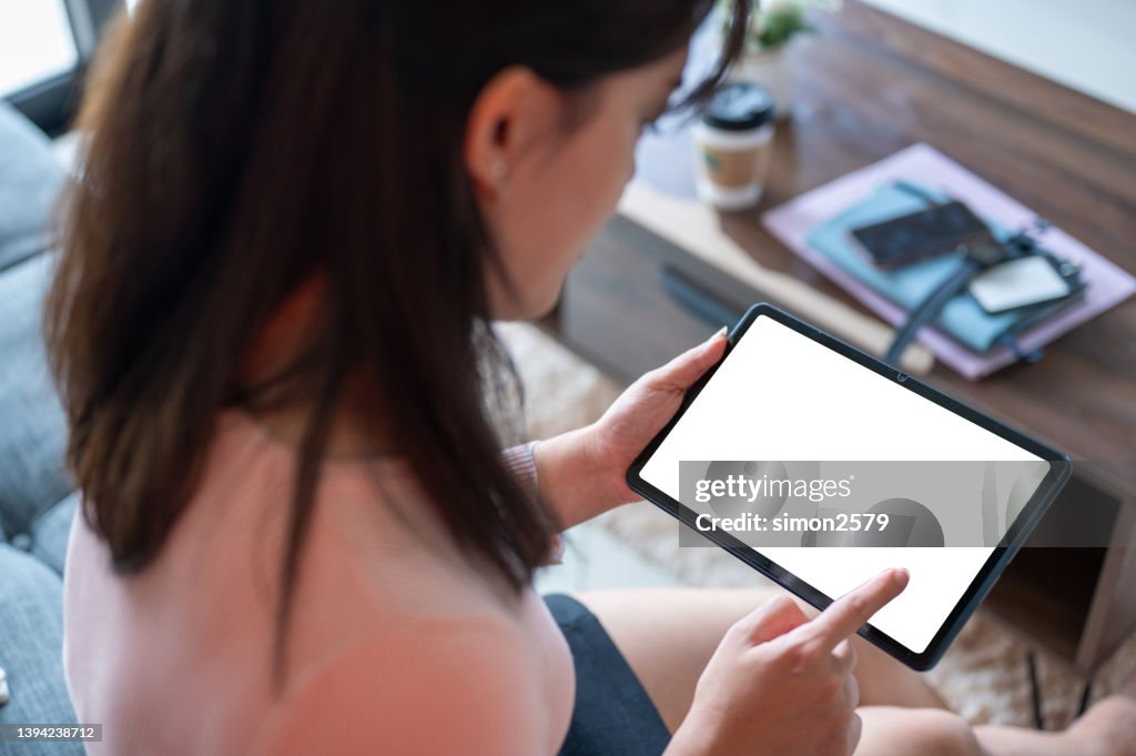 Woman looking at blank digital tablet