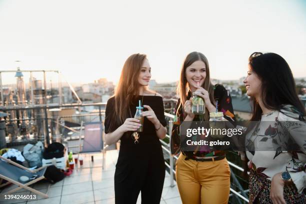 drei junge frau trinken cocktails im freien - cocktail sonnenuntergang stock-fotos und bilder