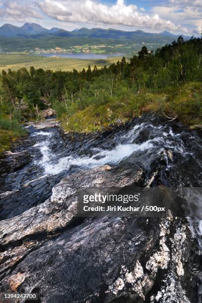 scenic view of stream flowing through rocks against sky - kuchar stock pictures, royalty-free photos & images