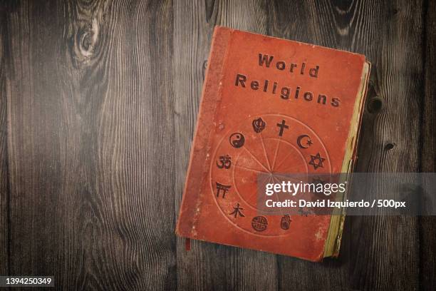 world religions book with symbols on wooden table top view - teologi bildbanksfoton och bilder