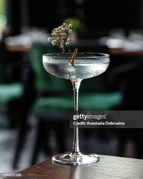 glass goblet of transparent cocktail garnished with flowers - table aperitif stock pictures, royalty-free photos & images