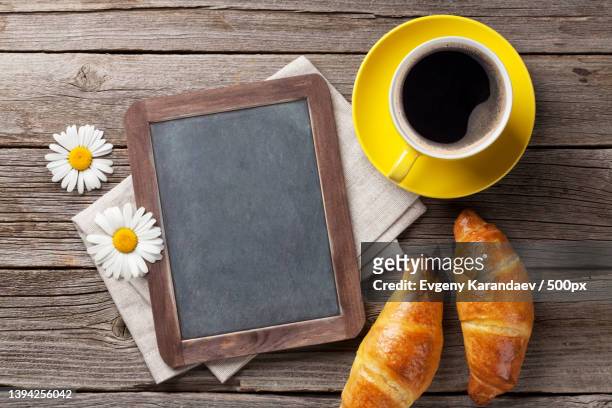 directly above shot of blackboard with coffee and croissants on wooden table - kreide tafel kräuter stock-fotos und bilder