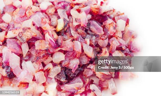 close-up of chopped pink and red onion on white background - oily slippery stockfoto's en -beelden