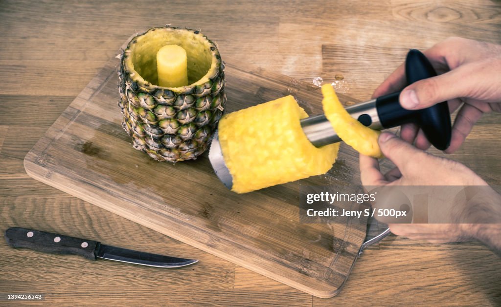 Cropped hand using a pineapple corer-slicer