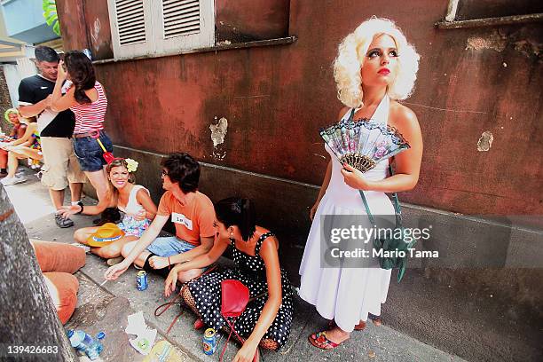 Brazilian reveler poses while others gather during Carnival celebrations on February 20, 2012 in Rio de Janeiro, Brazil. Carnival is the grandest...