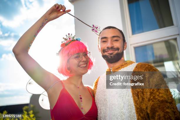 young woman as an elf with pink wig and a young man in bear costume - motto stock pictures, royalty-free photos & images