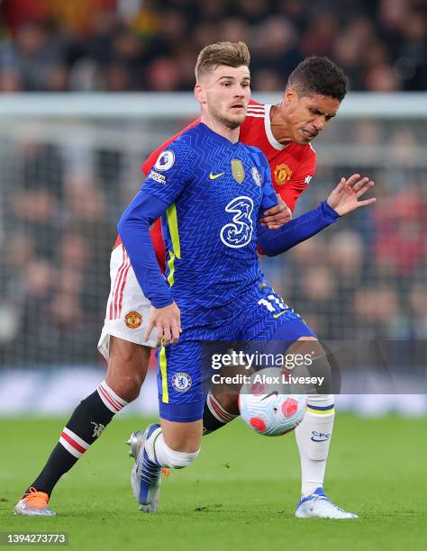 Timo Werner of Chelsea is challenged by Raphael Varane of Manchester United during the Premier League match between Manchester United and Chelsea at...