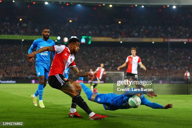 Reiss Nelson of Feyenoord shoots under pressure from Luan Peres of Marseille during the UEFA Conference League Semi Final Leg One match between...