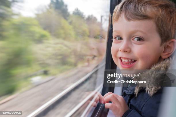 happy young boy traveling on a train - railways uk stock pictures, royalty-free photos & images