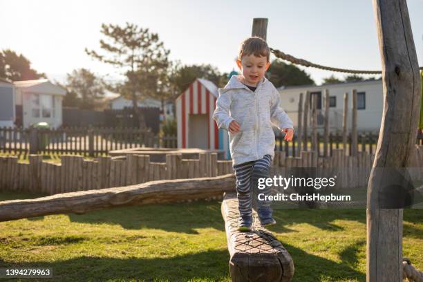 young boy balancing on beam at play park - playground balance beam stock pictures, royalty-free photos & images