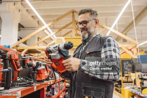 carpenter shopping en ferretería. - instrumentos fotografías e imágenes de stock