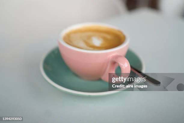 pink cup on a gray saucer with a teaspoon full of brown coffee - cafe pink silver stock pictures, royalty-free photos & images