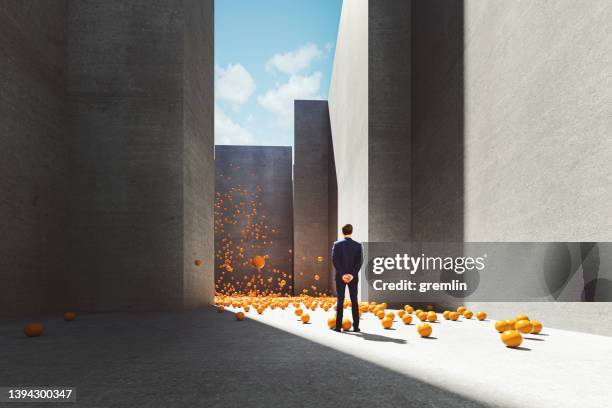 abstract businessman standing in maze with exploding spheres - bouncing ball stockfoto's en -beelden