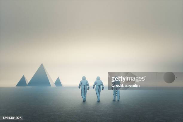 神秘的なピラミッドに向かって歩く宇宙飛行士たち - ピラミッド ストックフォトと画像